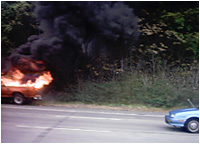 Truck burning on side of road